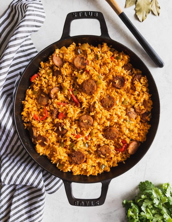 large skillet with chicken sausage and yellow rice