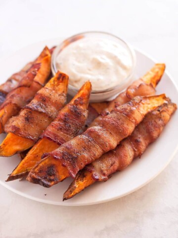 Sweet potatoes cut into fries, seasoned with salt, pepper, and smoked paprika, then wrapped in uncured applewood smoked bacon and baked to perfection!