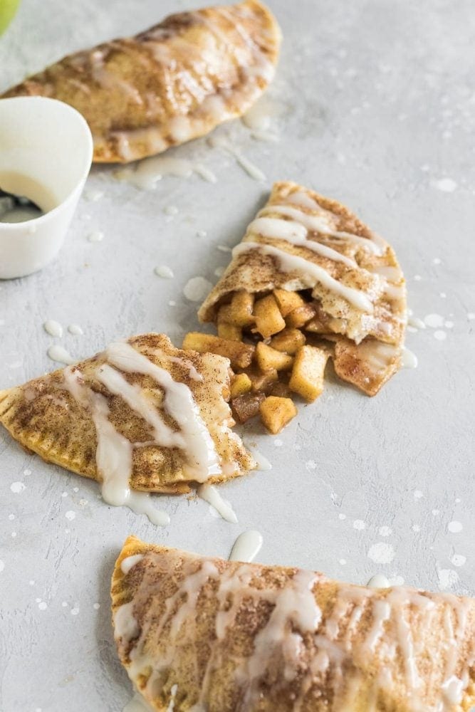 These baked apple pie empanadas with a buttery brown sugar apple filling and a spiced rum icing drizzle are the perfect party snack!