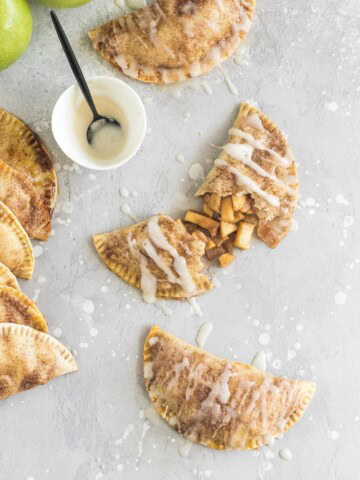 These baked apple pie empanadas with a buttery brown sugar apple filling and a spiced rum icing drizzle are the perfect party snack!
