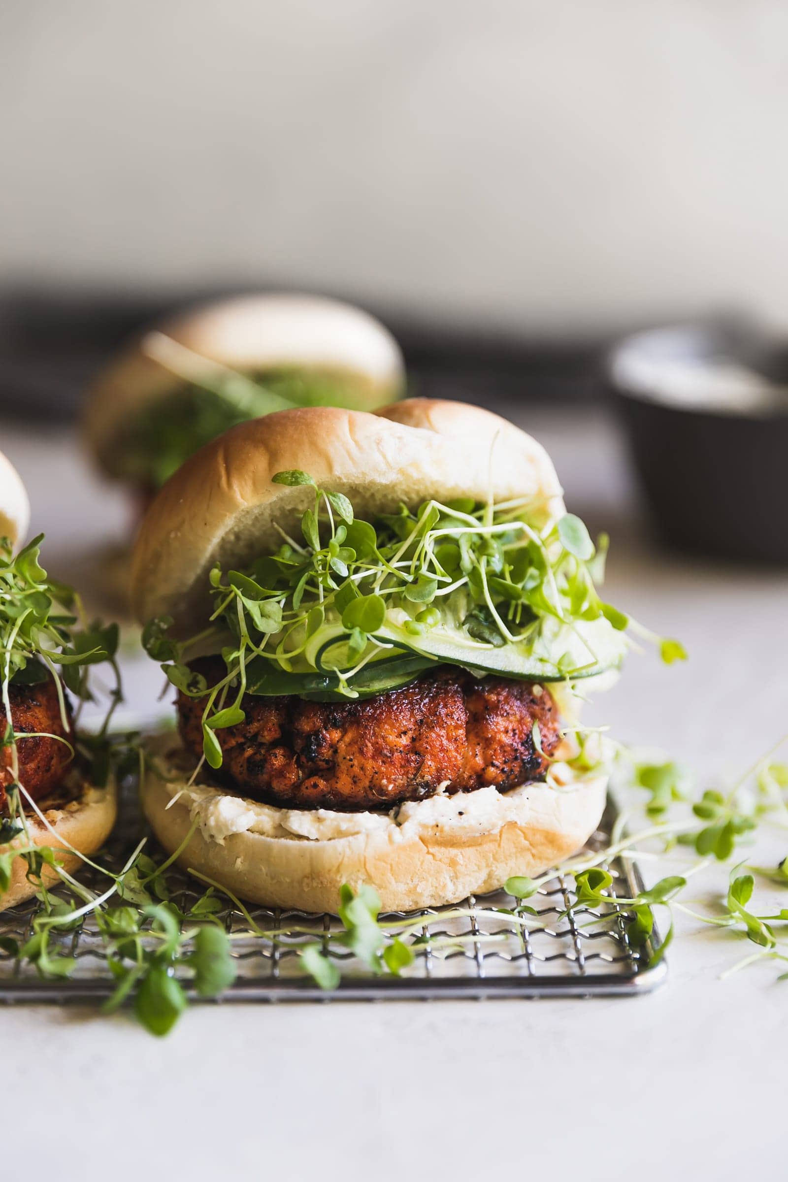 Easy-to-make, smoky, blackened salmon burgers made with smoked paprika, a pinch of cayenne, cumin, oregano and a queso fresco cream cheese spread!