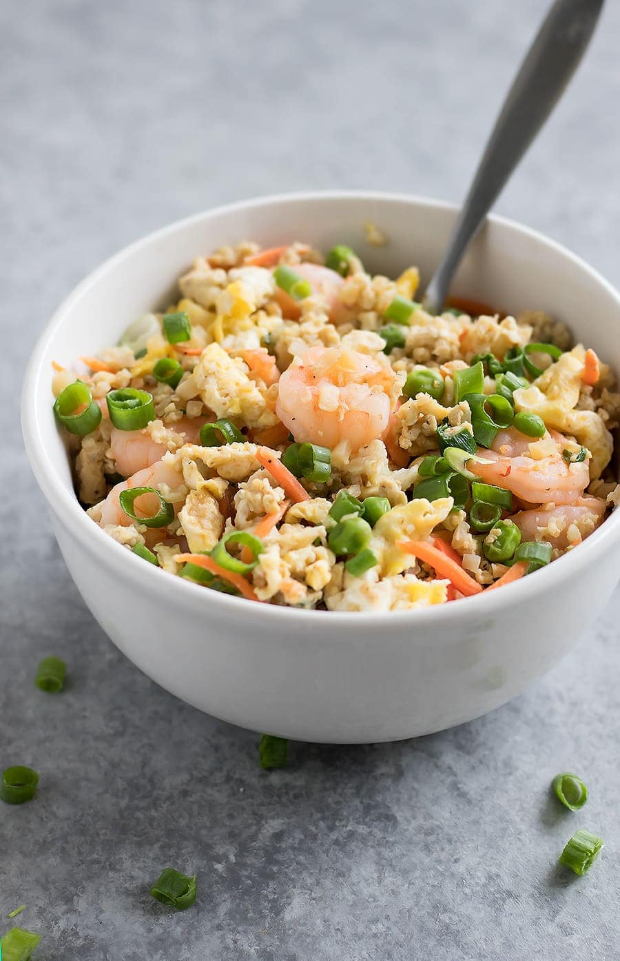 Forget takeout. Make Cauliflower Shrimp Fried Rice at home using riced cauliflower, carrots, peas, onions, garlic, and coconut aminos in just 15 minutes!