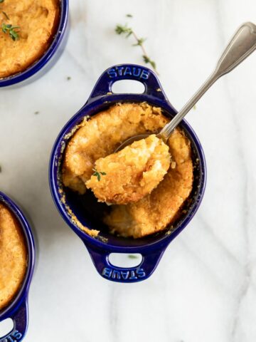 1. Mini French onion soup gratinée in blue Staub cocotte with melted cheese.