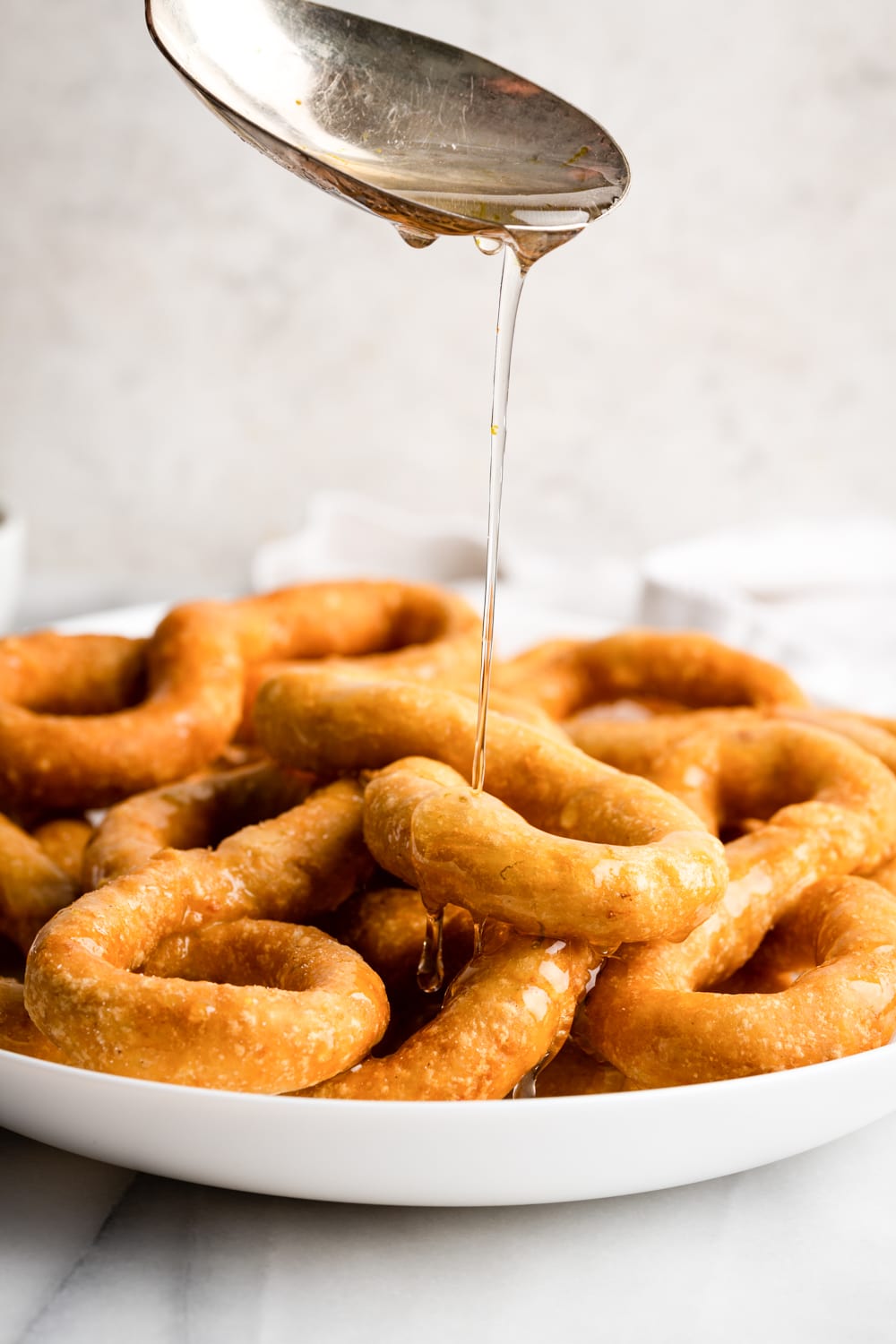 anise syrup being poured over the fried bunuelos