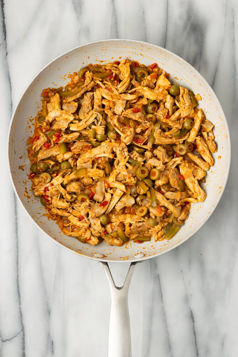 Cuban Chicken Empanada Filling in a pan with marble background