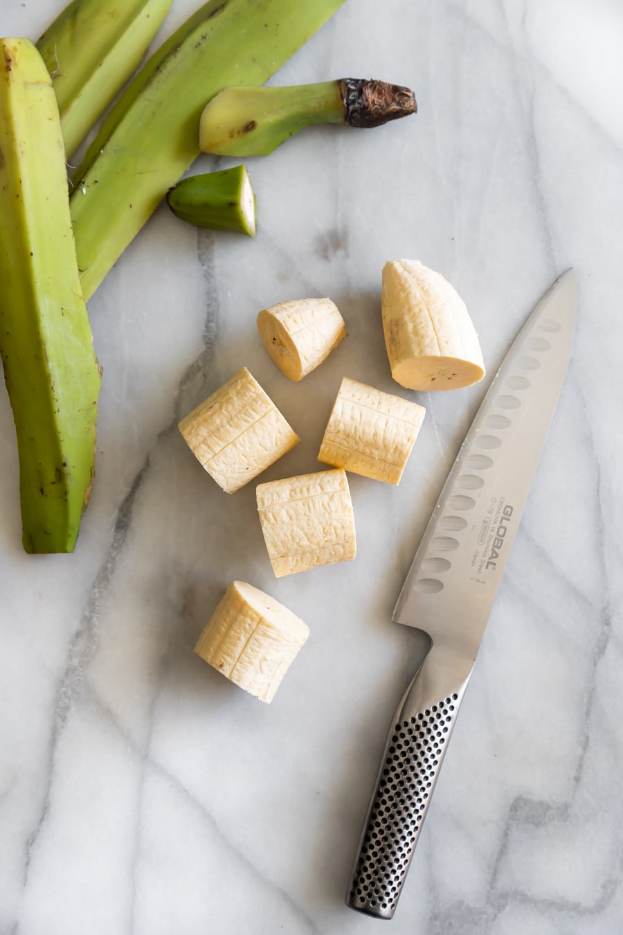 slicing the green plantains with a sharp knife