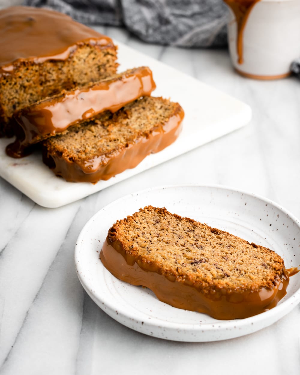 slice of banana bread with dulce de leche on a white plate