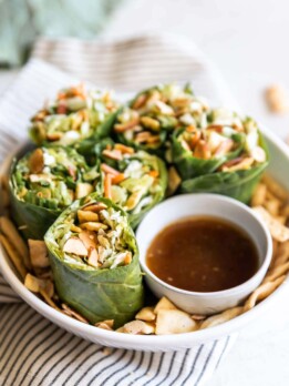 Simple collard green wraps made with avocado, savory green cabbage, carrots, celery, green onions, cilantro, toasted slivered almonds, crisp wontons, and sweet sesame ginger dressing!