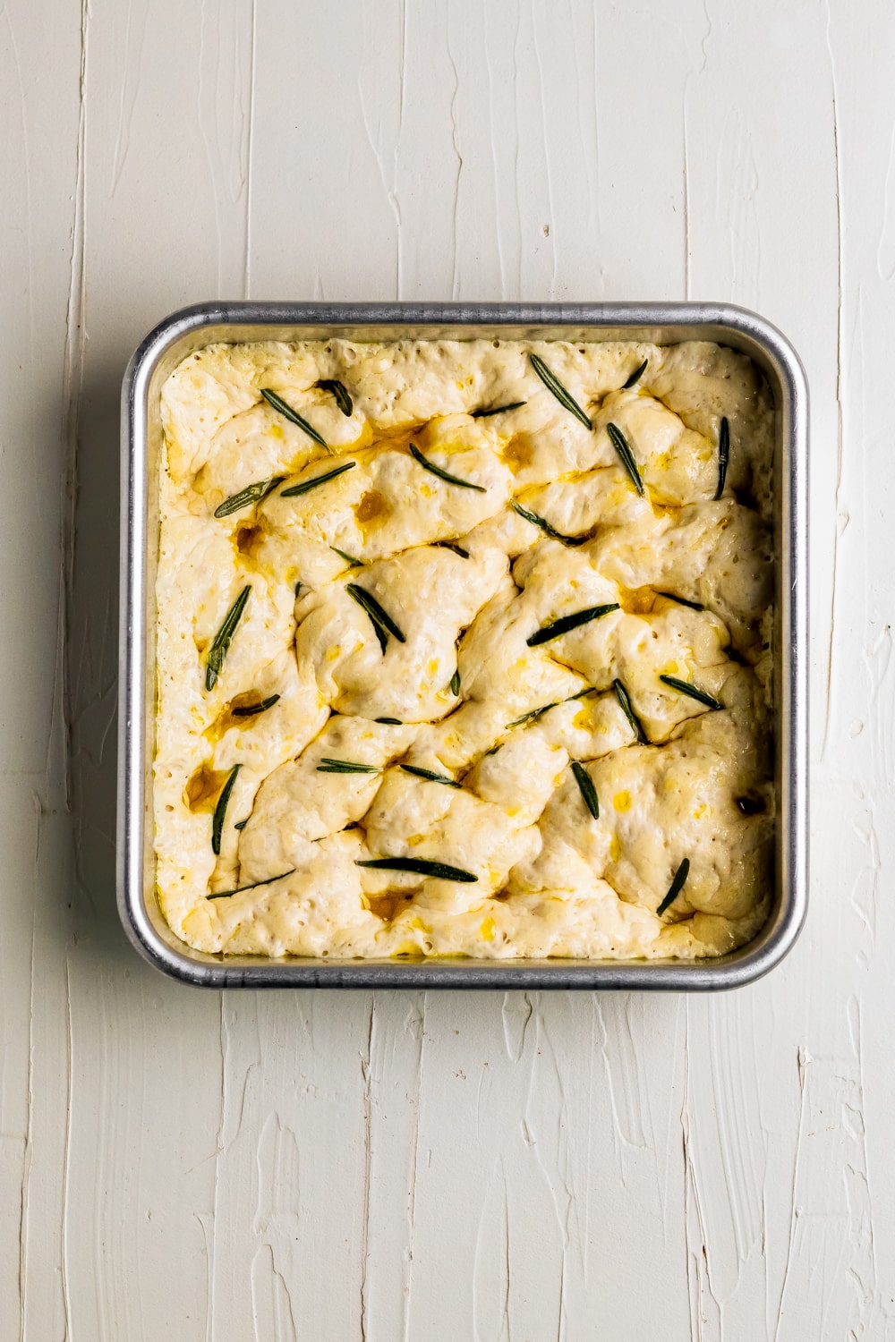 dough in baking dish with rosemary and sea salt