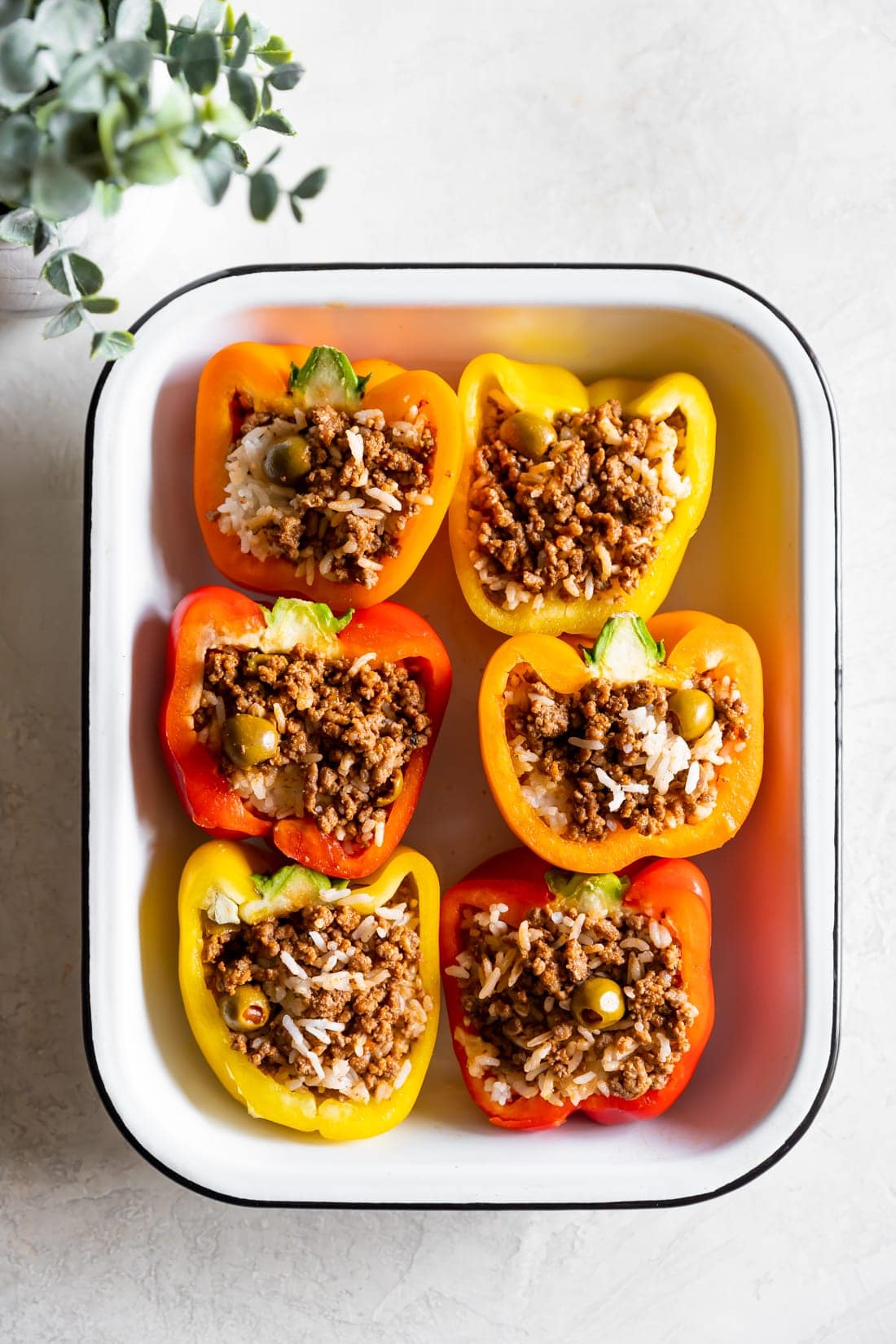 stuffed peppers with rice and ground beef in a baking dish