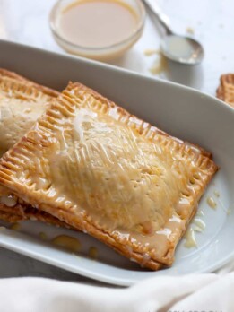 Super easy, semi-homemade guava and cream cheese pop tarts made using refrigerated pie crust then topped with a drizzle of condensed milk. The perfect combination of a Cuban treat on an American classic.