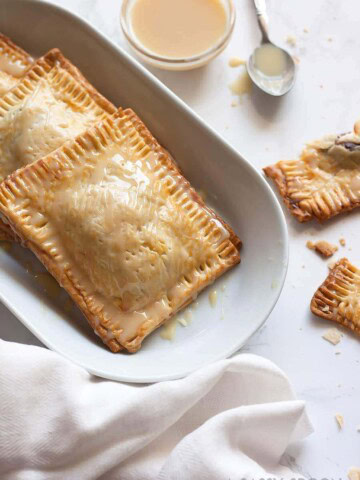 Super easy, semi-homemade guava and cream cheese pop tarts made using refrigerated pie crust then topped with a drizzle of condensed milk. The perfect combination of a Cuban treat on an American classic.