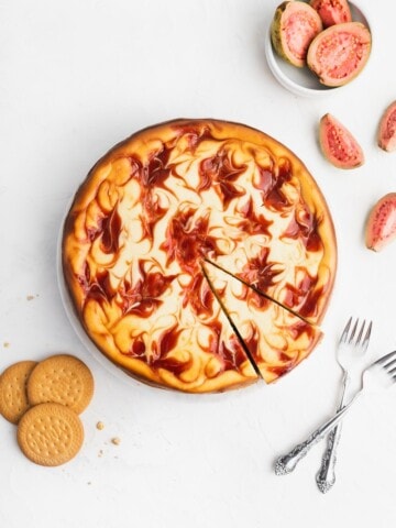 photo of guava swirl cheescake with guava fruit, maria cookies, and two forks