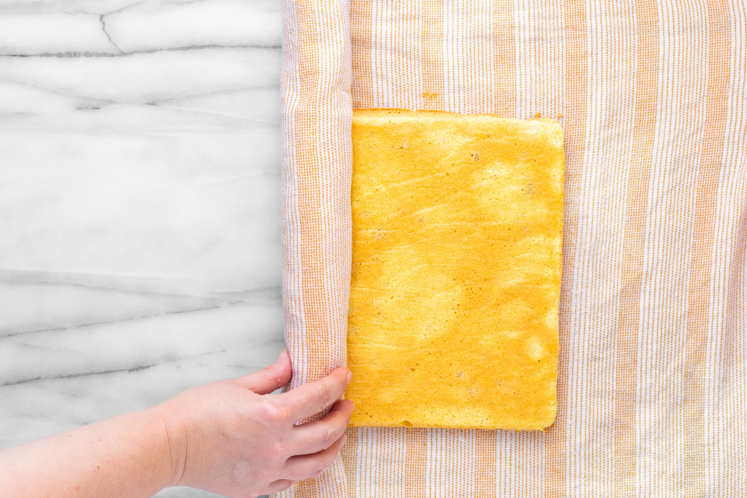 A brazo gitano getting rolled up with a damp towel before filling has been added