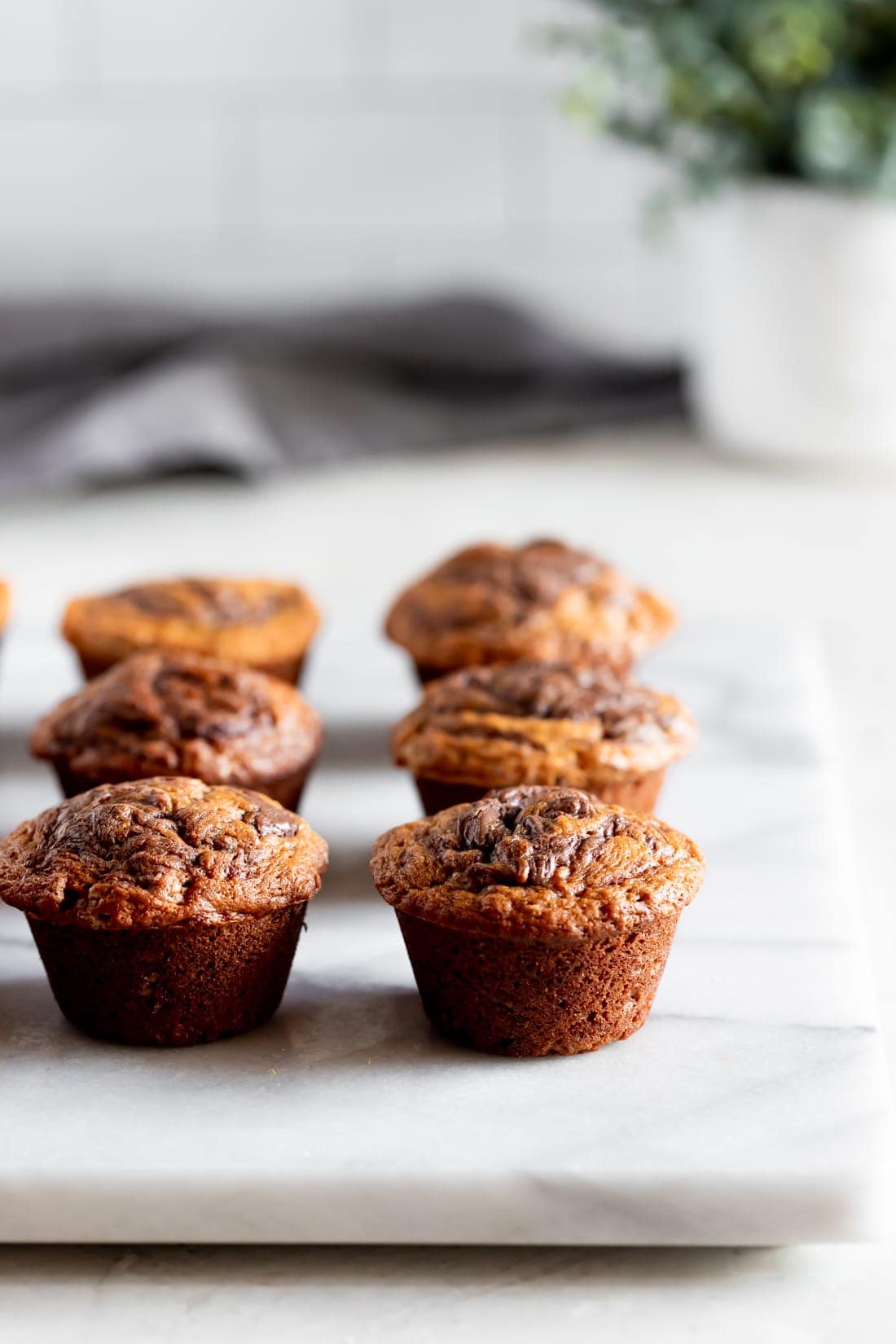 moist banana muffins swirled with nutella on a marble slab