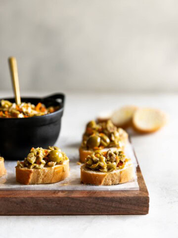 A simple yet irresistible appetizer made with tart, briny olives, capers, fresh garlic, pepper, and olive oil then served on toasted baguette slices brushed with olive oil.