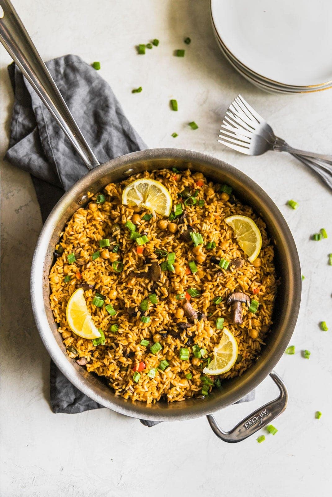 A quick and easy vegetarian paella made with brown rice, garbanzo beans, mushrooms, red peppers, and peas. Perfect weeknight meal!