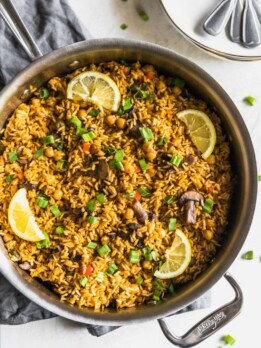 A quick and easy vegetarian paella made with brown rice, garbanzo beans, mushrooms, red peppers, and peas. Perfect weeknight meal!
