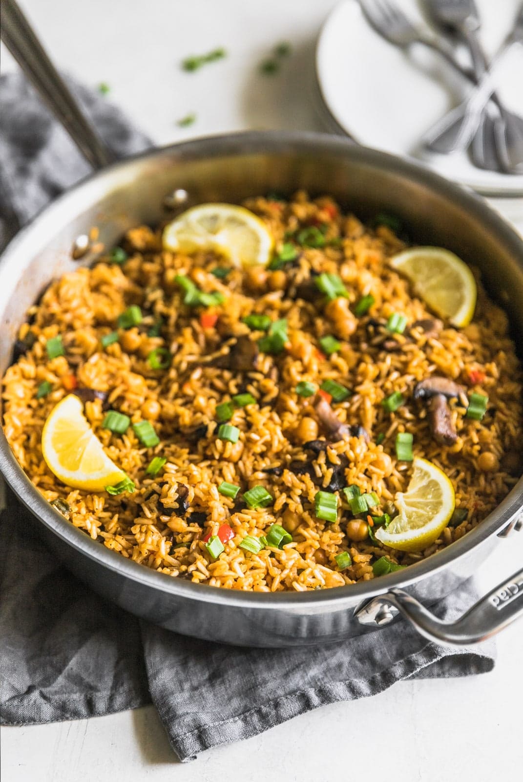 A quick and easy vegetarian paella made with brown rice, garbanzo beans, mushrooms, red peppers, and peas. Perfect weeknight meal!