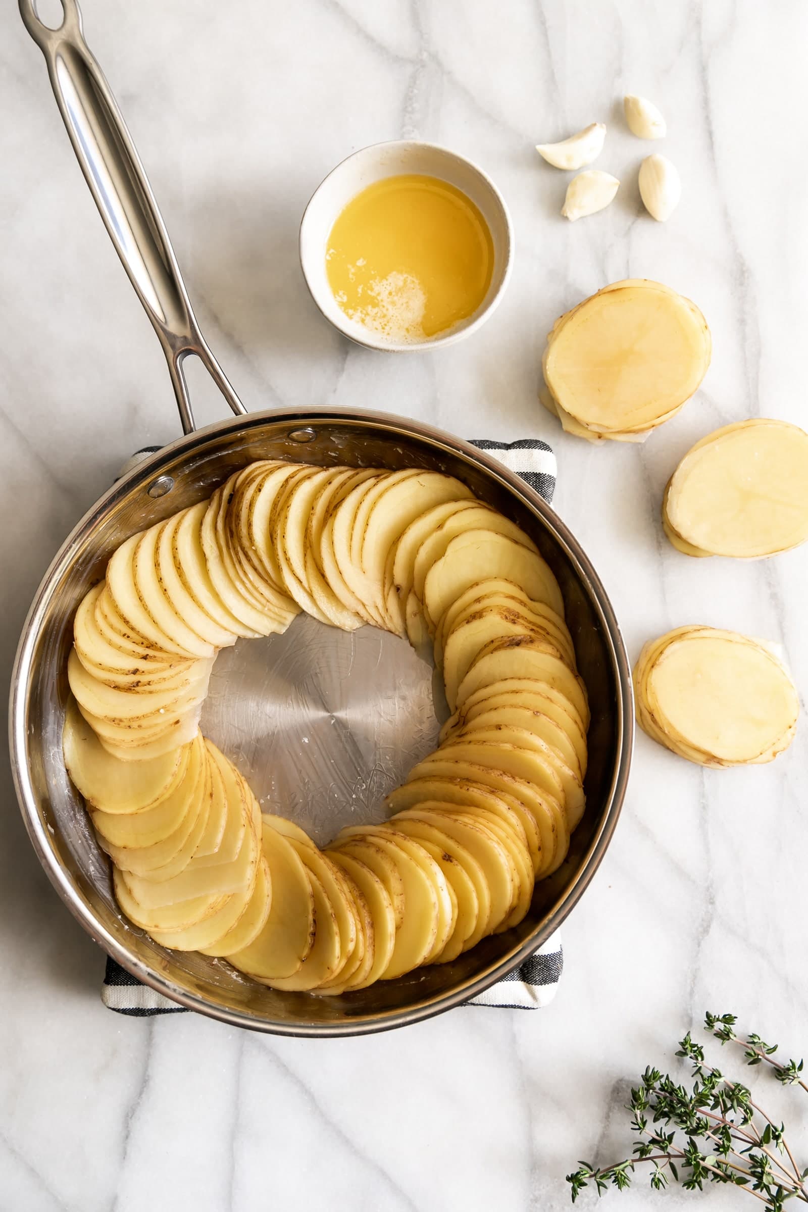 Thinly sliced gold potatoes tossed in garlic, butter, and thyme then roasted to perfection. An easy 5-ingredient side dish for any occasion!